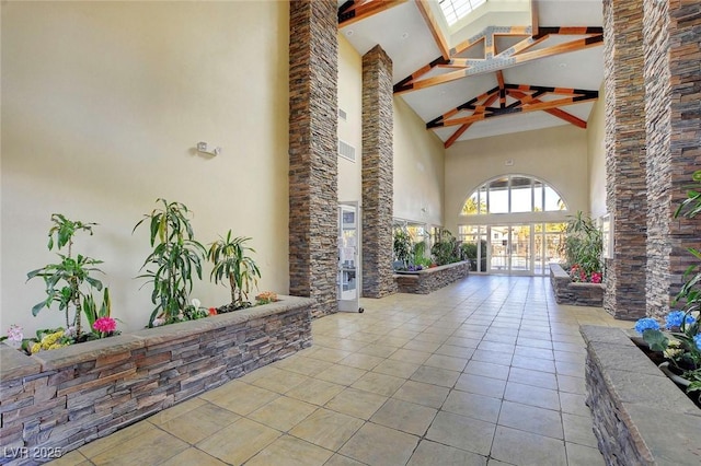 building lobby featuring high vaulted ceiling and beam ceiling