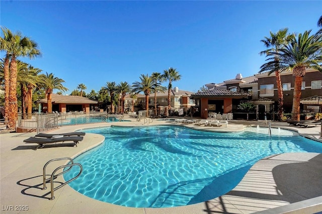 community pool featuring a patio and fence