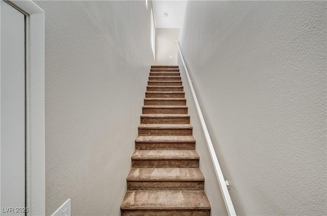 stairway featuring a textured wall