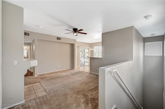 carpeted empty room with a ceiling fan and baseboards