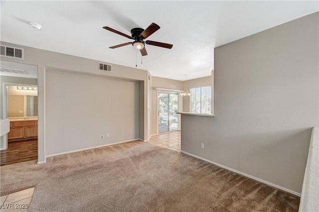 spare room featuring ceiling fan, carpet floors, and baseboards