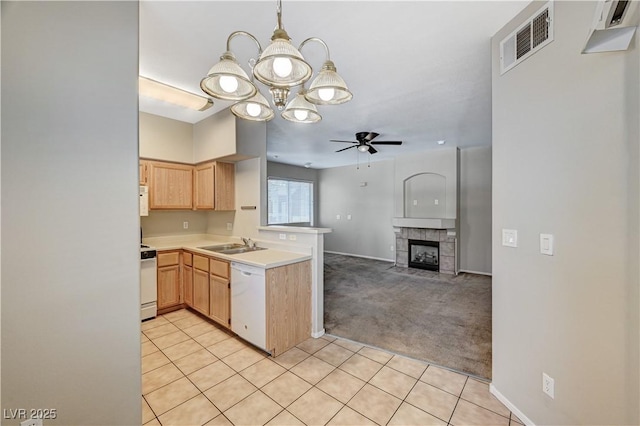kitchen featuring white appliances, a peninsula, a chandelier, a sink, and a ceiling fan