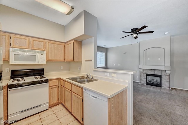 kitchen with white appliances, light brown cabinets, a sink, ceiling fan, and a peninsula