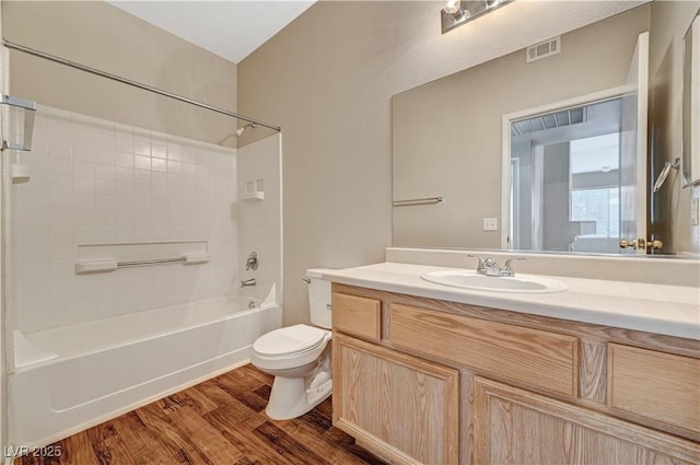 full bathroom featuring toilet, wood finished floors, vanity, and washtub / shower combination