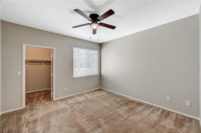 unfurnished bedroom with a spacious closet, carpet floors, baseboards, and a closet