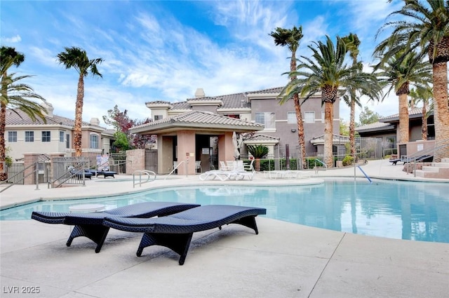 community pool featuring fence and a patio area
