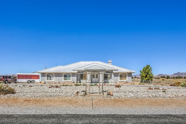 1410 Tiptop Trl, Pahrump, NV 89048 - view of front of property featuring a chimney, stucco siding, a mountain view, and a tiled roof