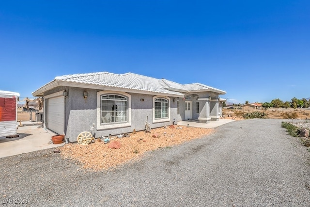 1410 Tiptop Trl, Pahrump, NV 89048 - view of front facade with a tile roof, a garage, stucco siding, and driveway
