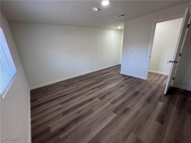unfurnished bedroom featuring dark wood-style flooring, baseboards, and recessed lighting