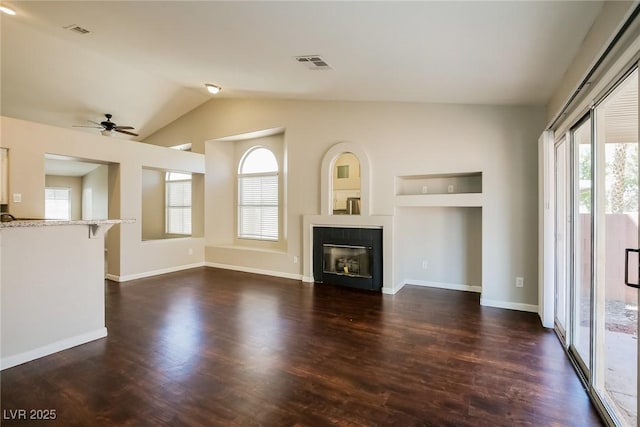3416 Steppe St, North Las Vegas, NV 89032 - unfurnished living room with ceiling fan, dark wood-style flooring, a tiled fireplace, lofted ceiling, and baseboards