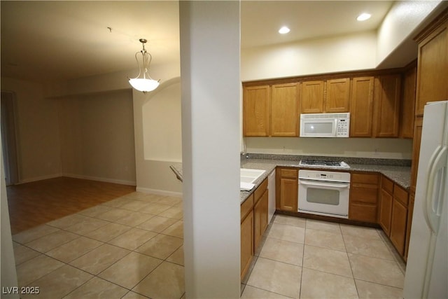 62 E Serene Ave Unit 129, Las Vegas, NV 89123 - kitchen with white appliances, light tile patterned floors, brown cabinets, decorative light fixtures, and recessed lighting