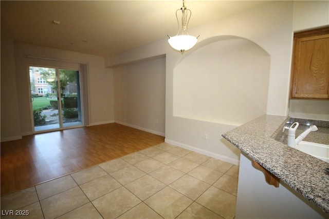 62 E Serene Ave Unit 129, Las Vegas, NV 89123 - unfurnished dining area with a sink, light tile patterned floors, and baseboards