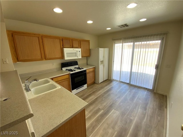 5474 Jacobs Field St, Las Vegas, NV 89148 - kitchen with white appliances, a sink, light countertops, recessed lighting, and light wood-type flooring