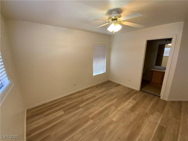 5474 Jacobs Field St, Las Vegas, NV 89148 - unfurnished bedroom with light wood-type flooring, baseboards, ensuite bath, and ceiling fan