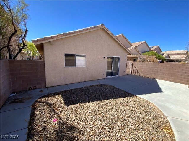 5474 Jacobs Field St, Las Vegas, NV 89148 - rear view of house featuring stucco siding, a fenced backyard, and a patio area