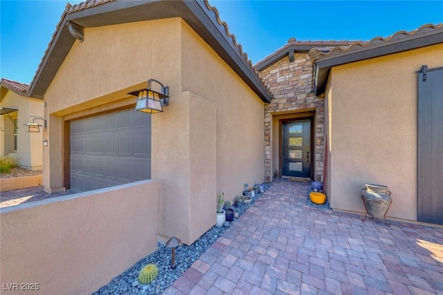125 Mirage View Dr, Henderson, NV 89011 - entrance to property with a garage, a tiled roof, stucco siding, and stone siding