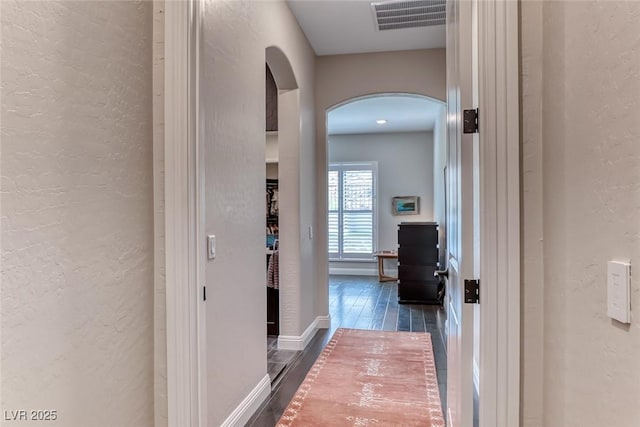 125 Mirage View Dr, Henderson, NV 89011 - hallway featuring arched walkways, a textured wall, and dark wood-style flooring