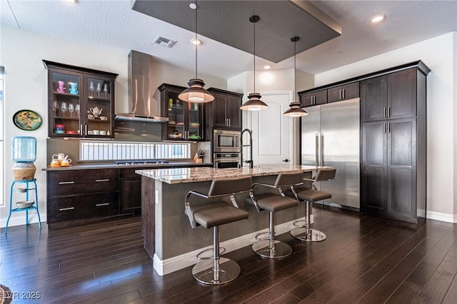 125 Mirage View Dr, Henderson, NV 89011 - kitchen with built in appliances, wall chimney range hood, baseboards, and dark wood finished floors