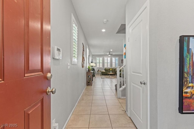 corridor featuring light tile patterned flooring, baseboards, and recessed lighting