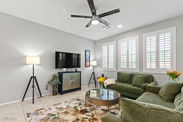 living area featuring a ceiling fan, baseboards, and light tile patterned flooring