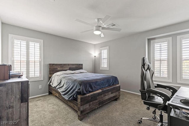 carpeted bedroom with a desk, baseboards, and ceiling fan