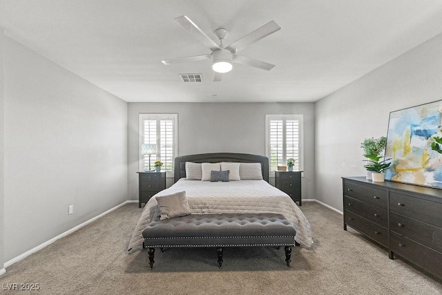 bedroom featuring light carpet, multiple windows, and baseboards