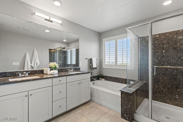 bathroom featuring a stall shower, tile patterned flooring, double vanity, a garden tub, and recessed lighting