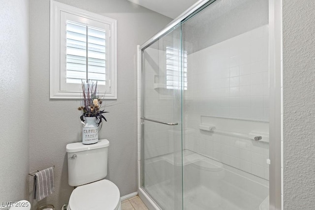 bathroom with a stall shower and toilet