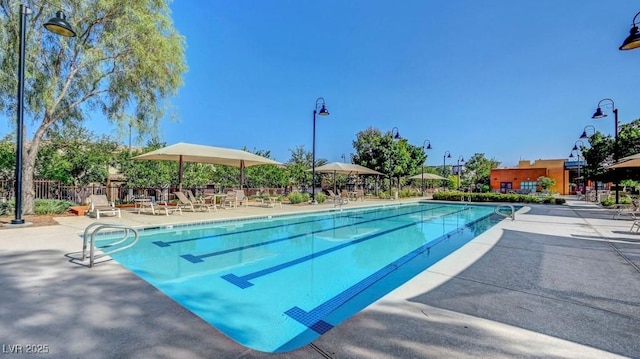 community pool with fence and a patio area