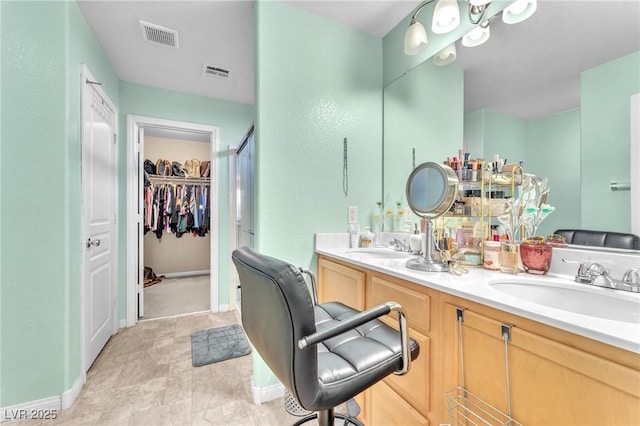 7115 Hickory Post Ave, Las Vegas, NV 89179 - bathroom featuring double vanity, a spacious closet, baseboards, and a shower with door