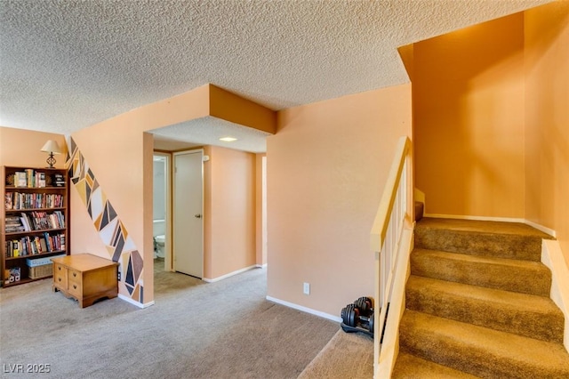 staircase featuring carpet flooring, a textured ceiling, and baseboards