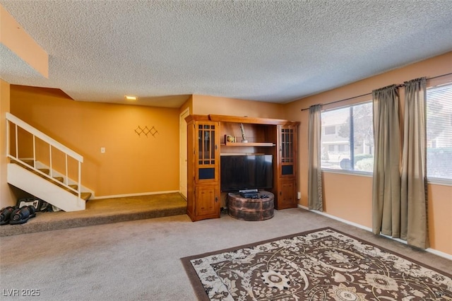 living room featuring a textured ceiling, carpet floors, stairs, and baseboards