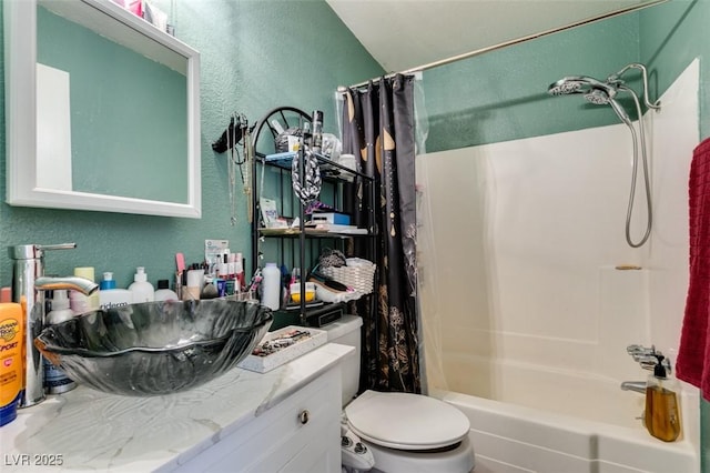bathroom with a textured wall, toilet, and vanity