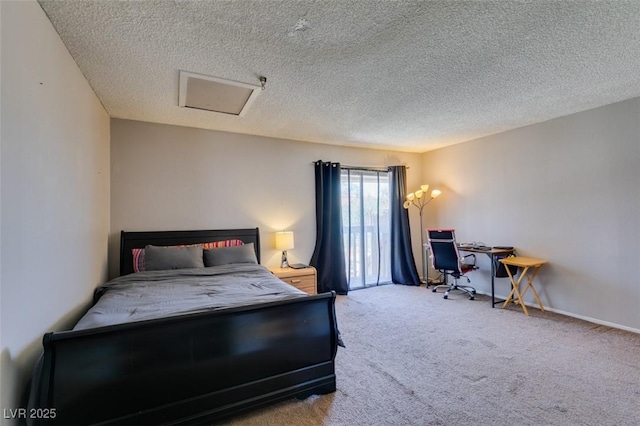 carpeted bedroom featuring attic access, a textured ceiling, and an office area