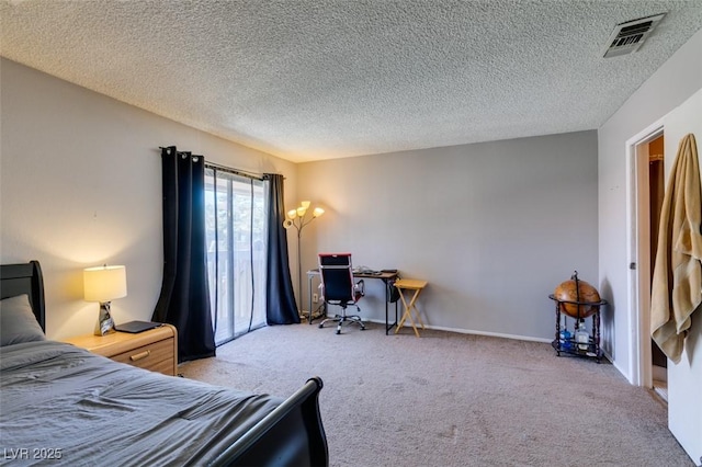 bedroom featuring carpet flooring, an office area, and a textured ceiling