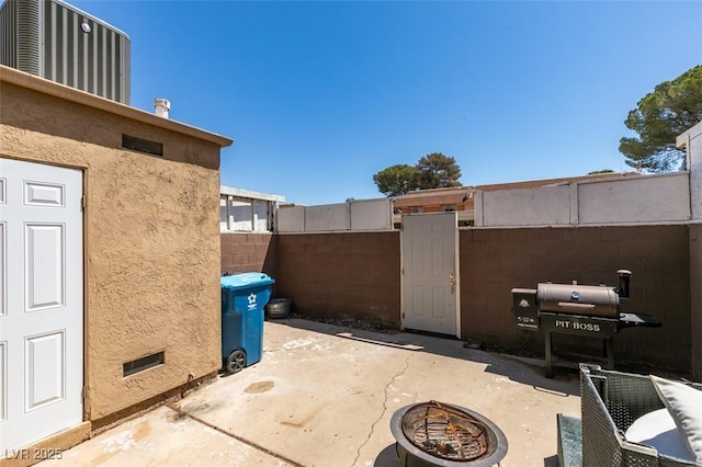 view of patio / terrace with an outdoor fire pit, fence, and a grill
