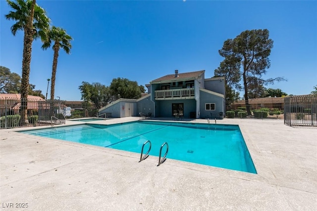 community pool with fence and a patio area