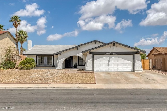 325 Heather Dr, Henderson, NV 89002 - ranch-style home with a garage, concrete driveway, a gate, stucco siding, and a chimney