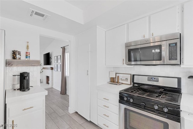 325 Heather Dr, Henderson, NV 89002 - kitchen with stainless steel appliances, light countertops, white cabinets, and backsplash