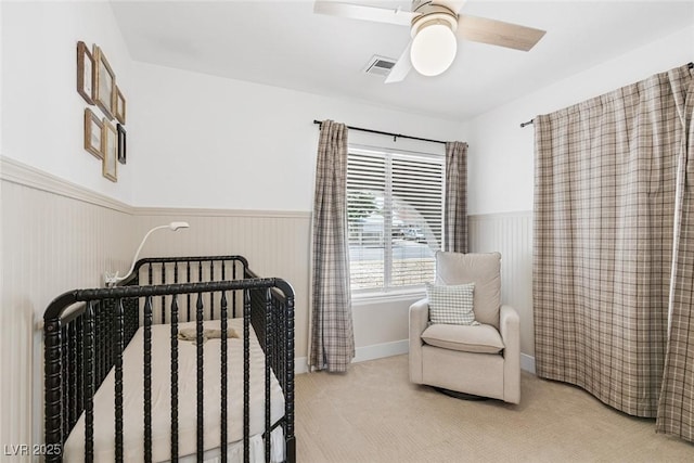 325 Heather Dr, Henderson, NV 89002 - carpeted bedroom featuring wainscoting, a crib, and a ceiling fan