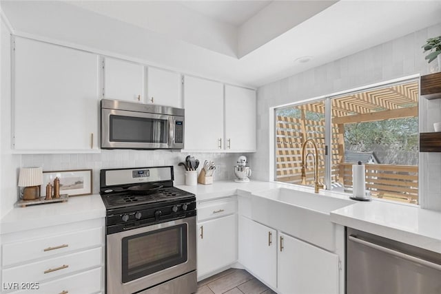 325 Heather Dr, Henderson, NV 89002 - kitchen featuring stainless steel appliances, light countertops, a sink, white cabinets, and backsplash