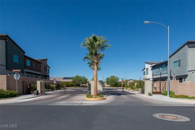 6145 May River St, Las Vegas, NV 89148 - view of asphalt street with traffic signs, curbs, and a gate