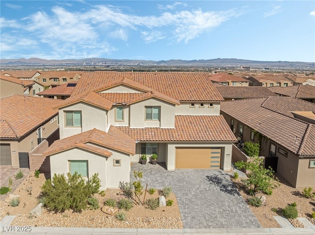 212 Harris Peak St, Las Vegas, NV 89138 - view of front facade featuring stucco siding, a tiled roof, decorative driveway, and a residential view