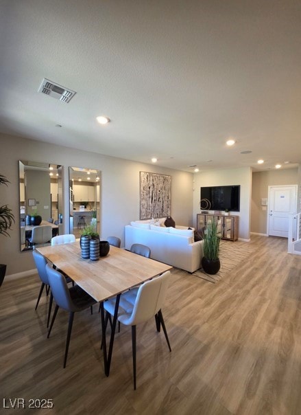 dining space featuring wood finished floors, baseboards, and recessed lighting