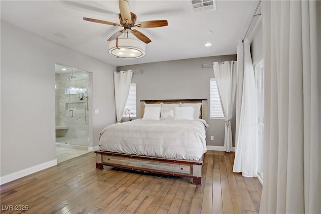 bedroom with ensuite bathroom, baseboards, wood finished floors, and recessed lighting