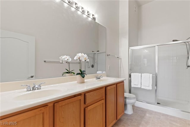 full bath with a shower stall, toilet, and double vanity