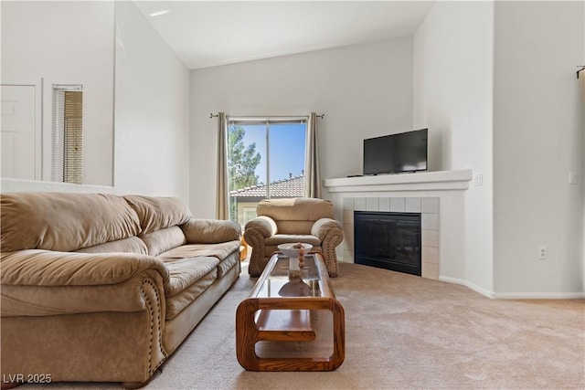 living room featuring lofted ceiling, a tile fireplace, carpet flooring, and baseboards