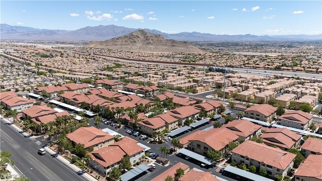 aerial view of property's location featuring a mountain backdrop and nearby suburban area