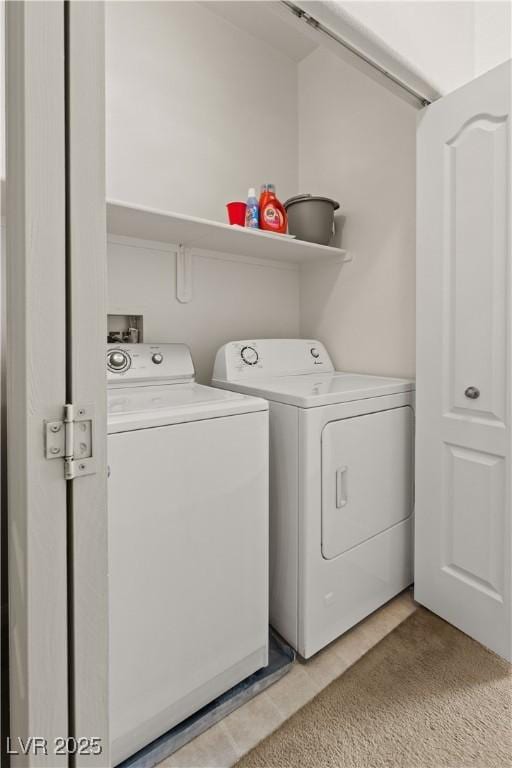 laundry room with washing machine and dryer and light tile patterned floors