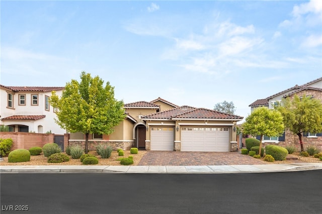 2116 Canvas Edge Dr, Henderson, NV 89044 - mediterranean / spanish-style house with a garage, stone siding, driveway, stucco siding, and fence